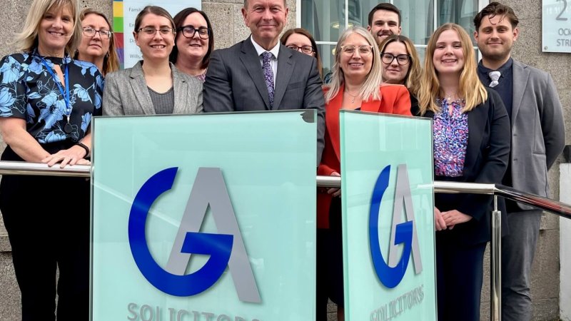 David Wallis standing outside the GA Solicitors Building with a number of new starters